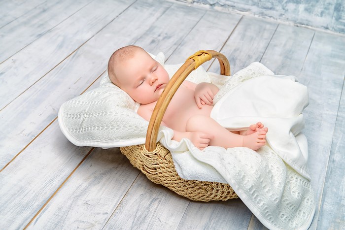 Infant sleeping in a wicker basket