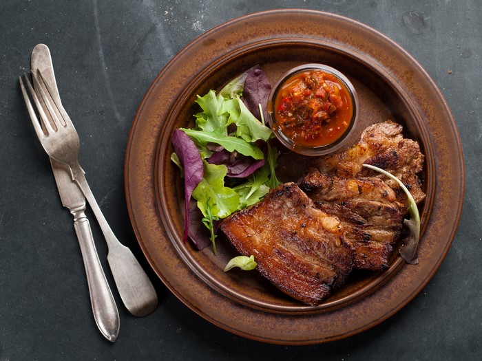 Grilled meat with salad and sauce on a plate