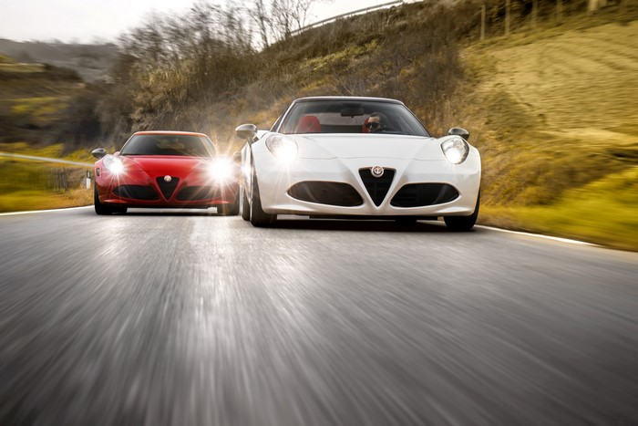 Two Alfa Romeo 4C Spider cars driving on a road