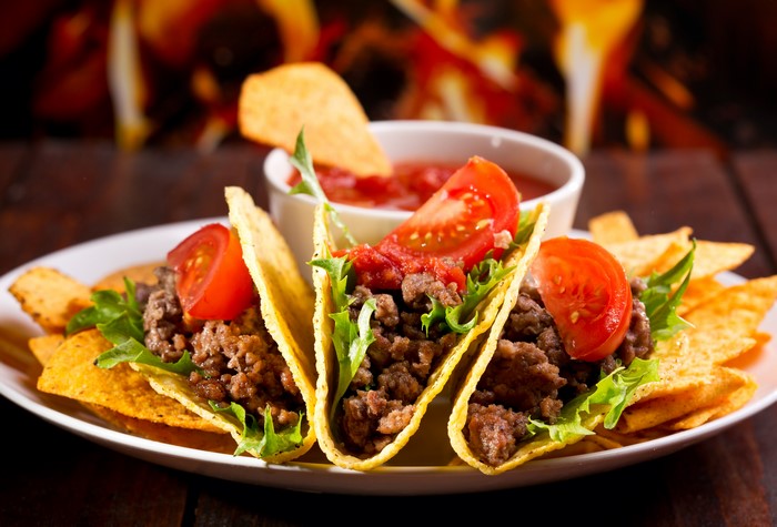 Tacos with meat, lettuce, tomato, and chips