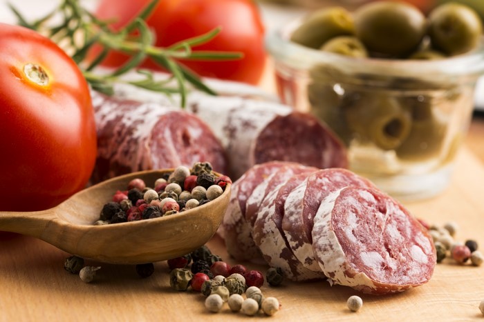 Sausage, Tomatoes, Olives, and Spices on a Wooden Board