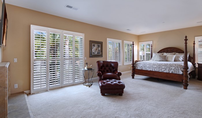 Bedroom with four-poster bed and armchair