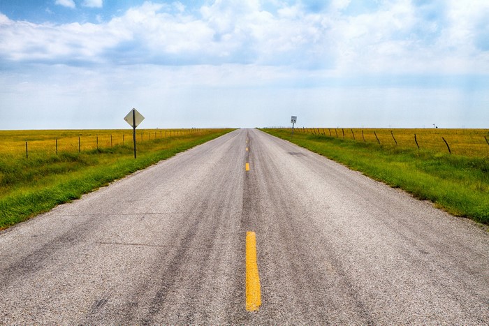 Empty asphalt road stretching to the horizon
