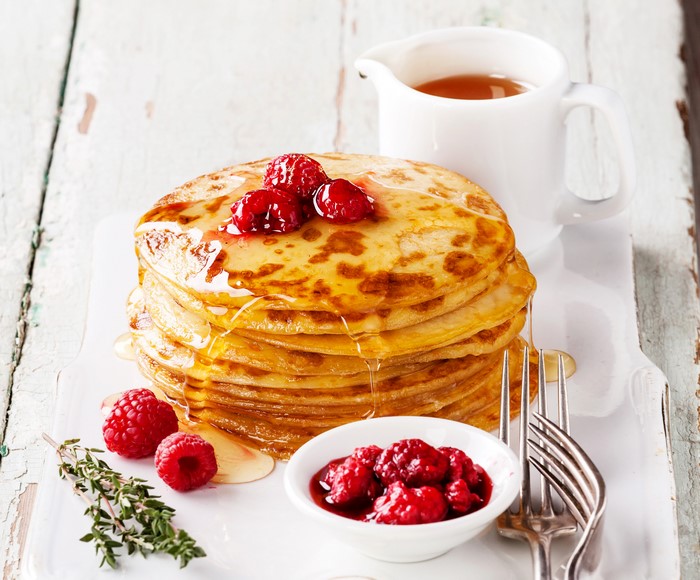 Stack of pancakes with raspberries and syrup