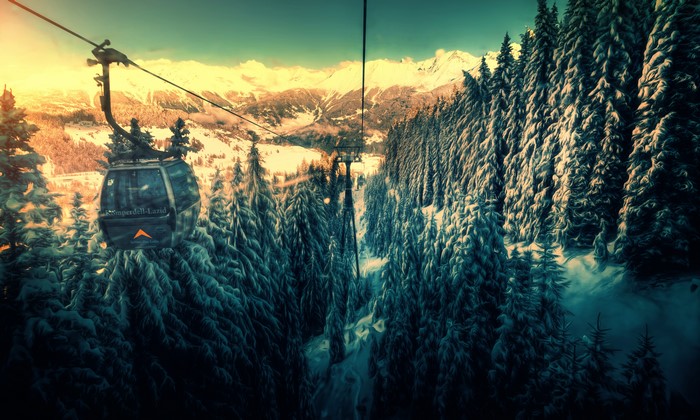 Cable car over snowy forest and mountains
