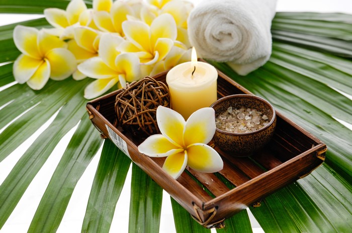 Spa setting with Plumeria flowers, candle, and salt