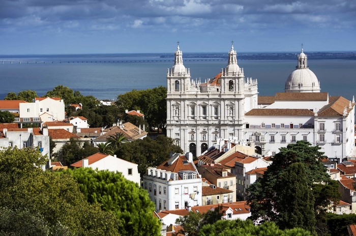 Lisbon cityscape with church and bridge over water