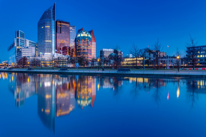 The Hague skyline reflected in a river at dusk