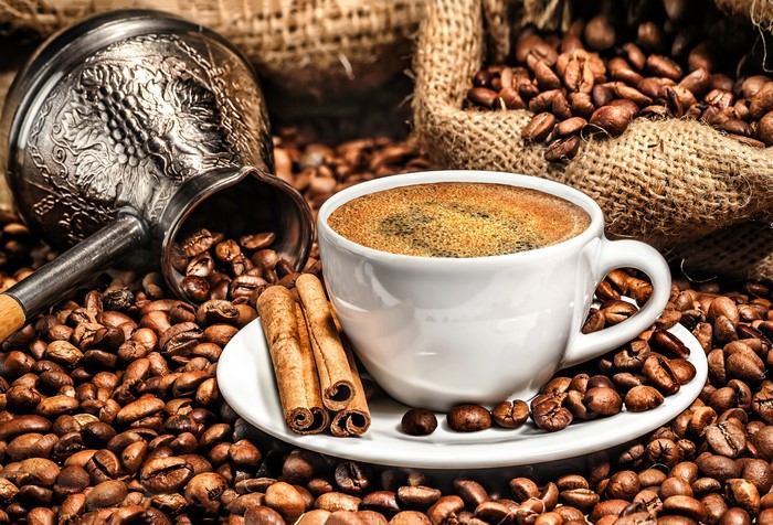 Coffee cup with cinnamon and coffee beans