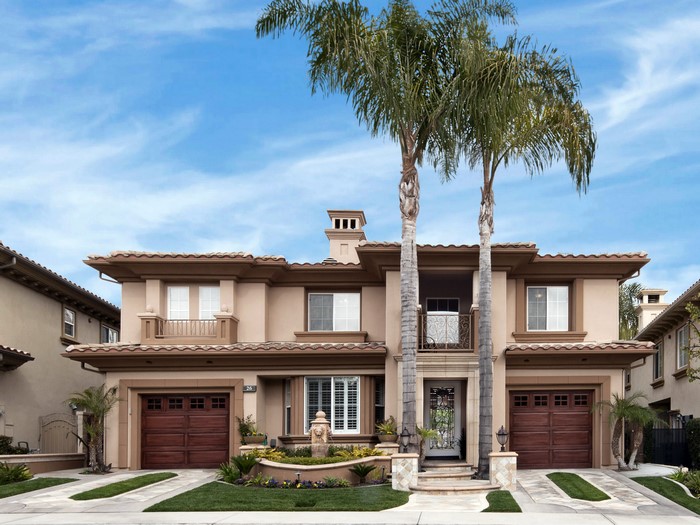 Two-story Mediterranean-style house with palm trees