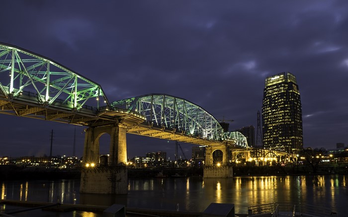 Bridge and skyscraper at night over a river in Nashville, Tennessee