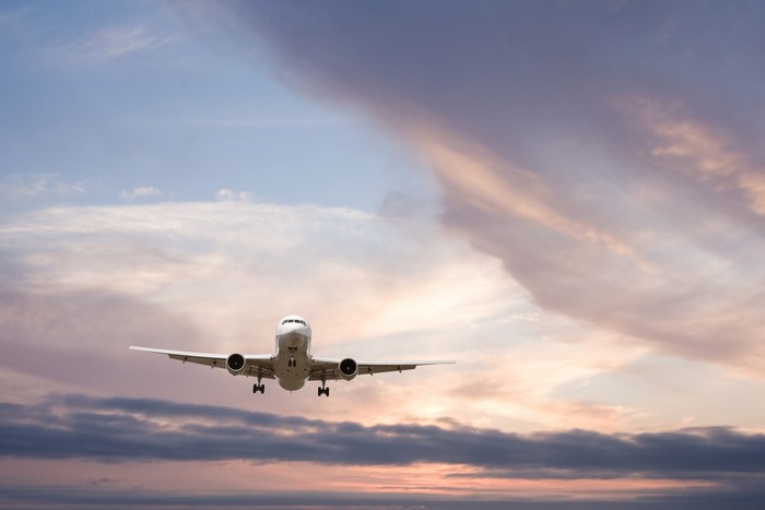 Airplane flying in the sky at sunset