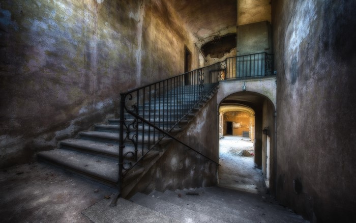 Abandoned building interior with grand staircase