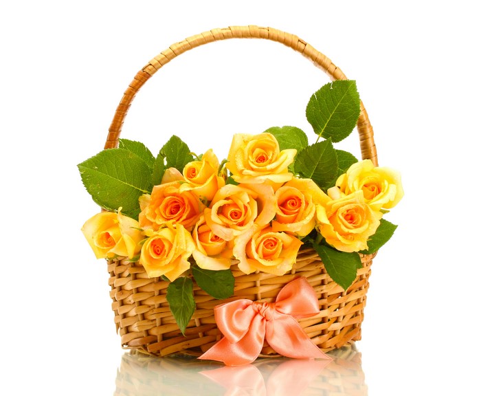 Yellow roses in a wicker basket with a pink bow
