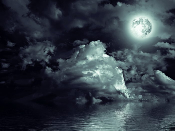 Full moon over water at night