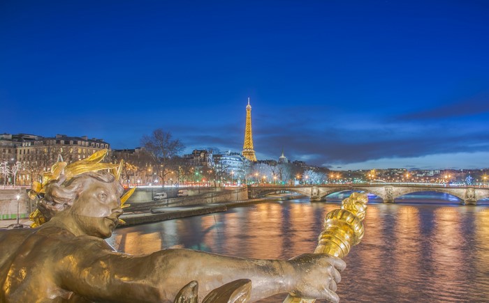 Eiffel Tower and bridges over the Seine River at night in Paris