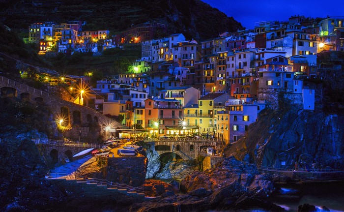 Manarola, Italy at night with colorful houses on a cliff