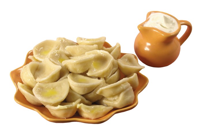 Pierogi with sour cream in a jug
