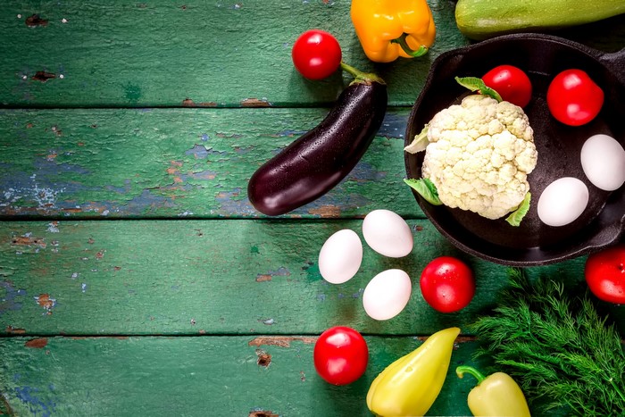Vegetables and eggs on a green wooden table