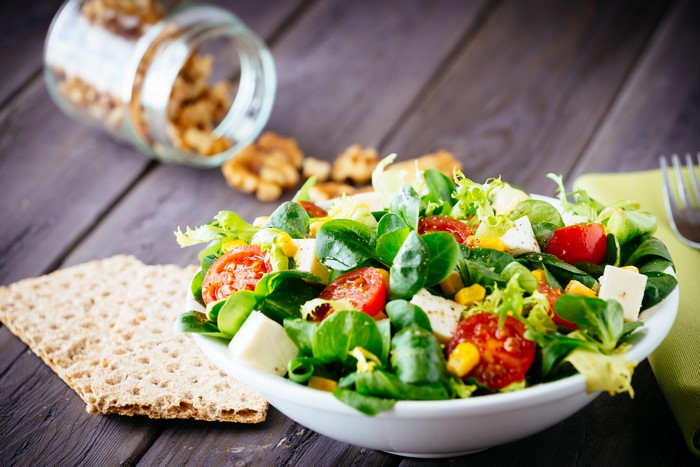 Salad with tomatoes, cheese, and corn with walnuts