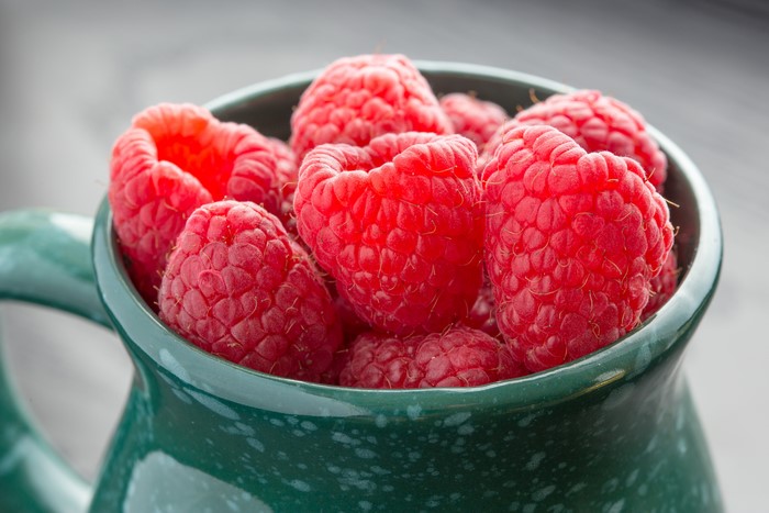 Raspberries in a green mug
