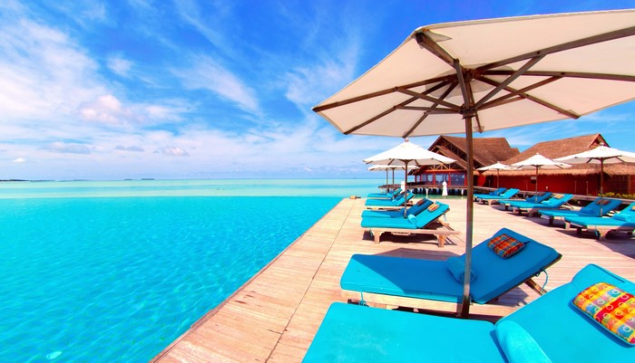 Infinity pool and sun loungers at a tropical resort