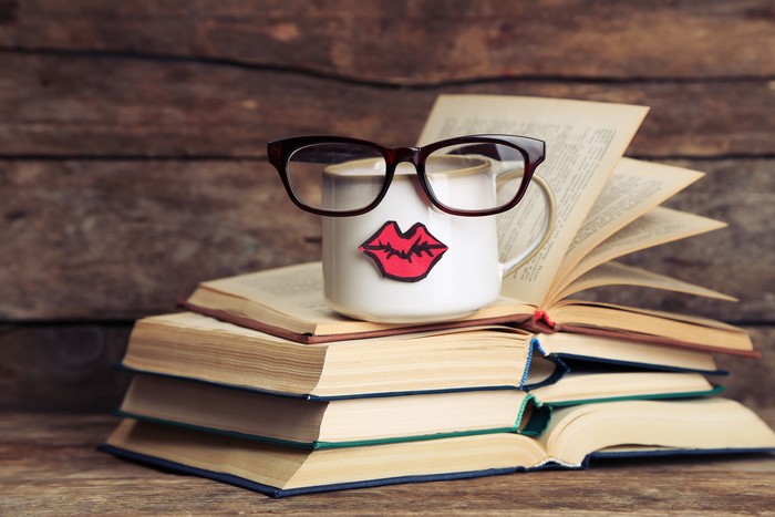 Mug with glasses and lips on books