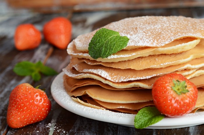 Stack of pancakes with strawberries and mint