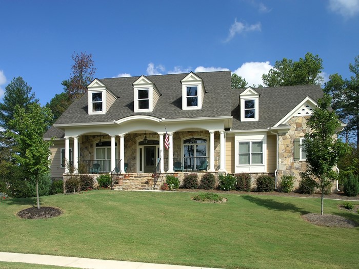 Large house with stone accents and a manicured lawn