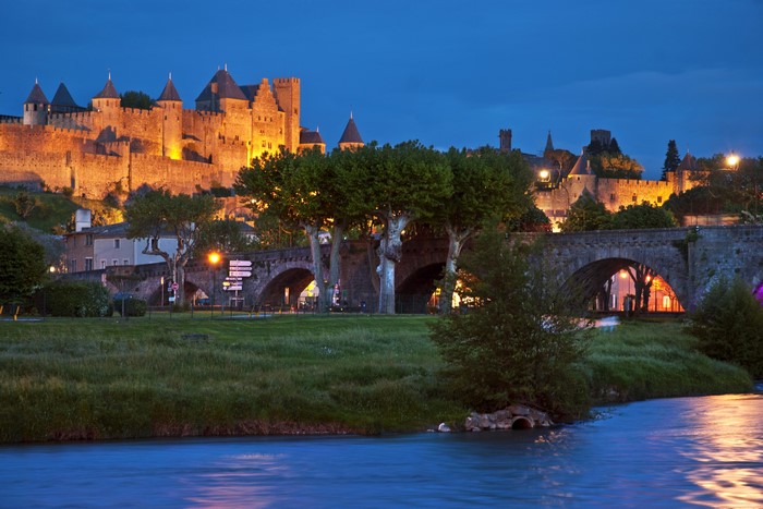 Fortress and bridge over river at dusk in Carcassonne, France
