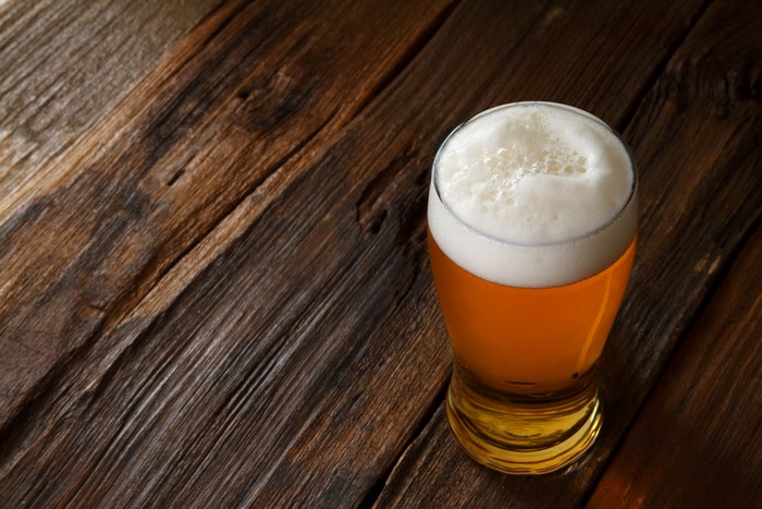 Beer in a highball glass on a wooden table