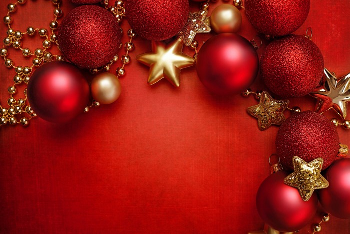Christmas ornaments and gold beads on red background