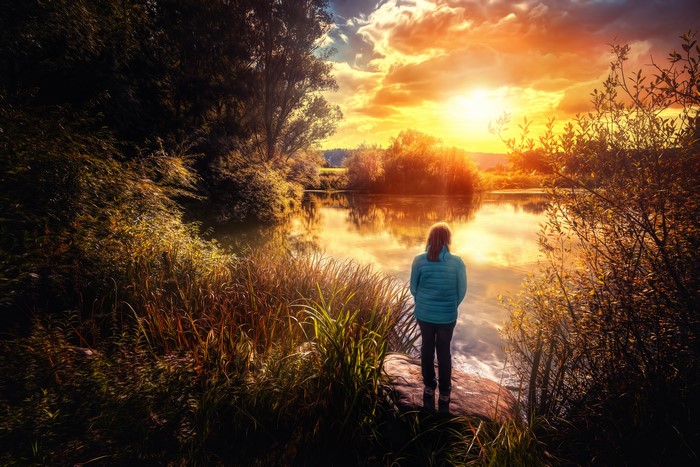Woman by lake at sunset