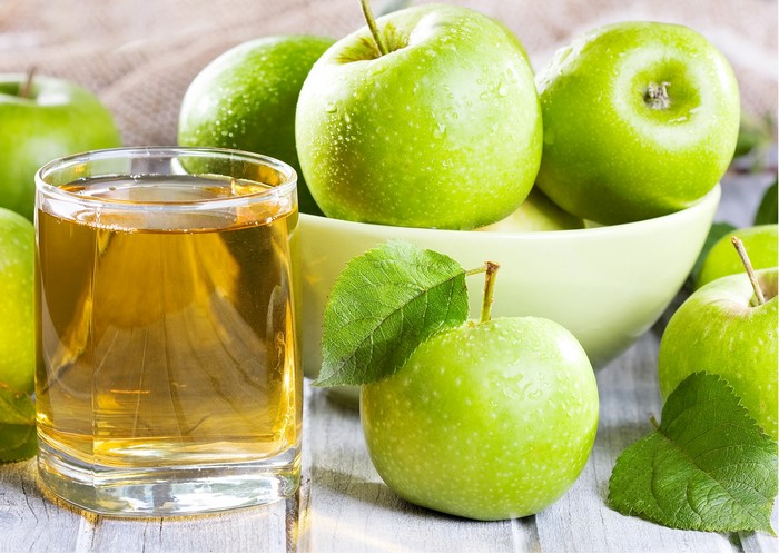 Green apples and apple juice in a glass
