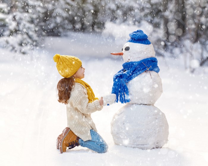 Girl and Snowman in Winter Forest