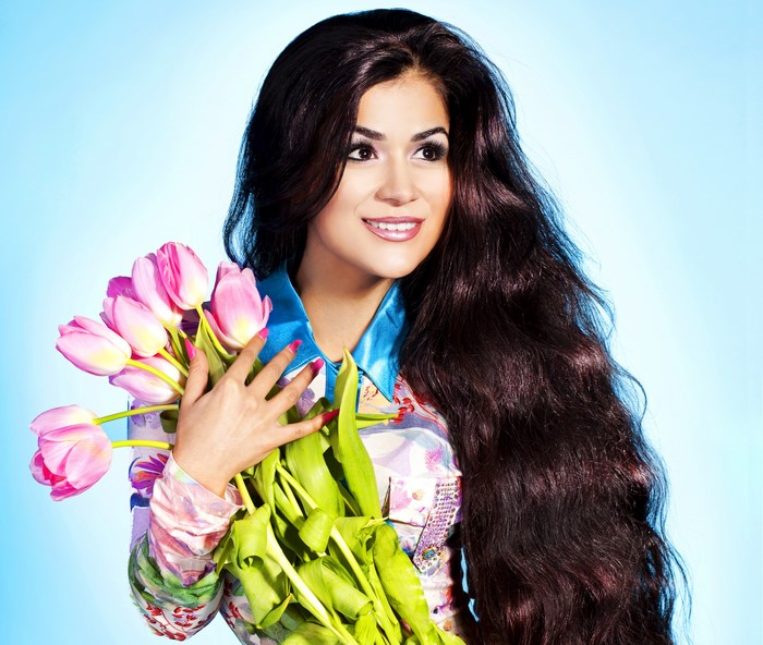 Woman with long brown hair holding pink tulips
