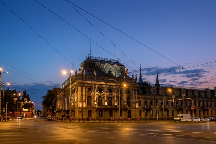 Street view of a historic building in Lodz, Poland at dusk