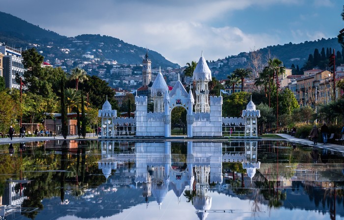 White castle structure reflected in a pond in Nice, France