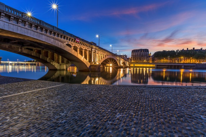 Bridge over river at night in Lyon, France