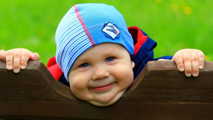Baby wearing a blue winter hat smiling