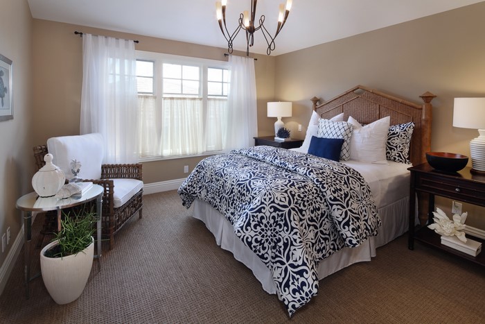 Bedroom with Wicker Armchair and Blue Patterned Bedding