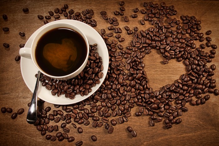 Coffee cup with heart shape in coffee and coffee beans