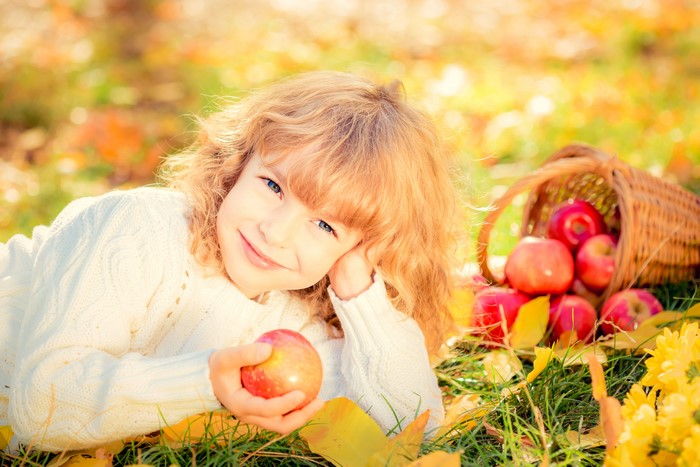 Little girl with apples in autumn