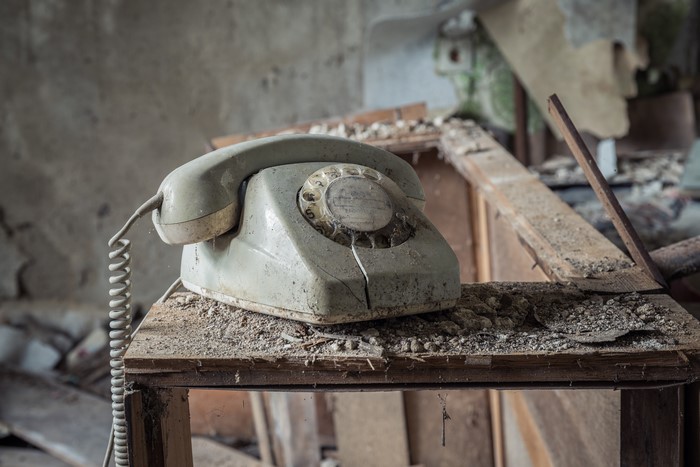 Retro rotary telephone on a table in an abandoned room