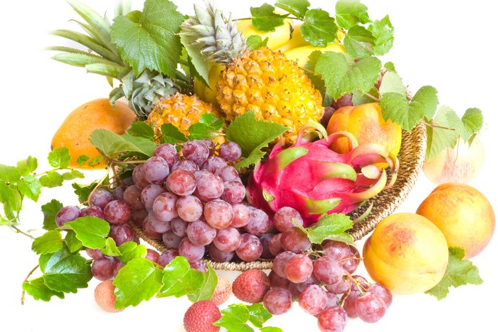 Fruit basket with pineapples, grapes, peaches, mango, and dragon fruit