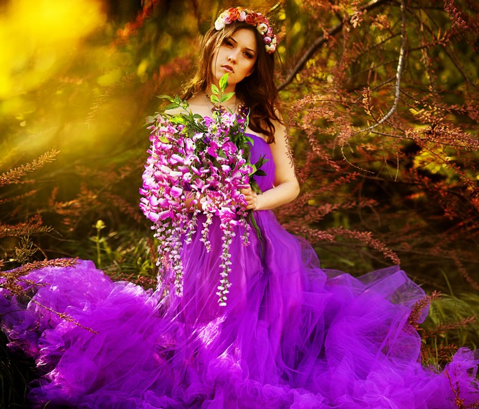 Woman in purple dress holding flowers