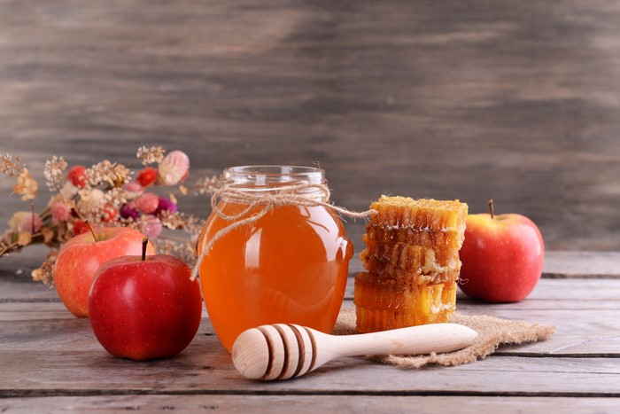 Apples, Honey, and Honeycomb on Wooden Table