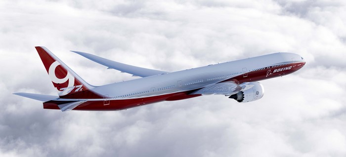 Boeing 777X airplane flying through clouds