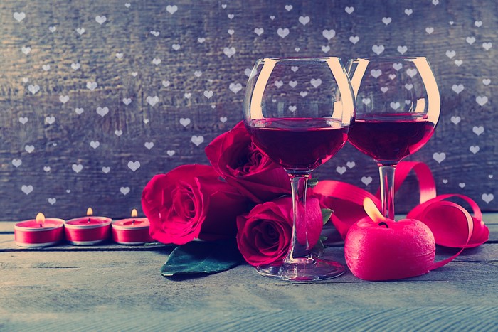 Red Roses, Wine Glasses, and Candles on Wooden Table
