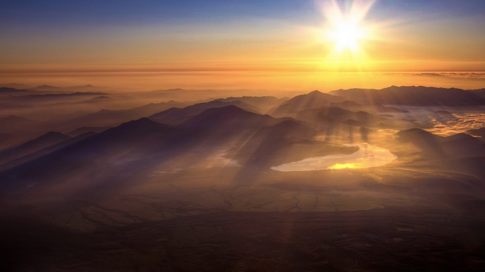 Sunrise over misty mountains and a lake